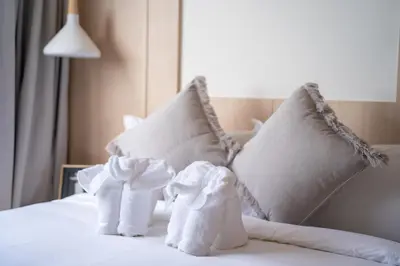 two towels are sitting on a bed with pillows at Japanese-Style Condo close Kamala Beach in Kamala Beach