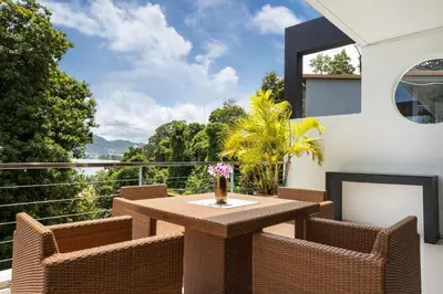 a patio with a table and chairs on a balcony at Private 3-Storey Pool Villa Atika 10, for 7, views of Patong Bay in Patong Beach