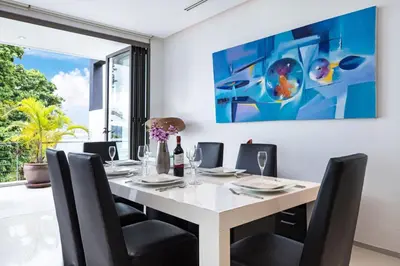 a dining room with a white table and black chairs at Private 3-Storey Pool Villa Atika 10, for 7, views of Patong Bay in Patong Beach