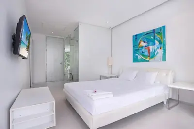 a white bedroom with a white bed and a tv at Private 3-Storey Pool Villa Atika 10, for 7, views of Patong Bay in Patong Beach