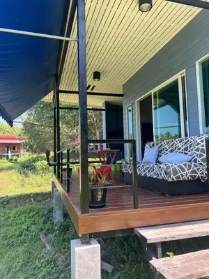 a porch with a couch and a table on a house at Nature Home in Phang-nga
