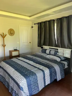 a bedroom with a bed with a blue and white blanket at Nature Home in Phang-nga