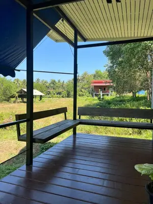 a porch with a bench on top of a field at Nature Home in Phang-nga