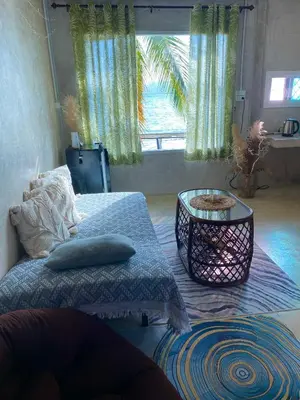 a bedroom with a bed and a table and a window at Beach Loft in Ko Thanan