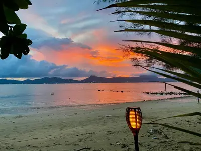 a street light on a beach with a sunset at Beach Loft in Ko Thanan
