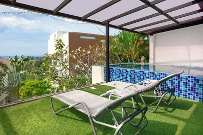 a patio with a table and chairs and a swimming pool at Nature and Sea View Terrace, Designer 2BR Villa Natural Touch A1, Kamala in Kamala Beach