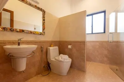 a bathroom with a sink and a toilet and a mirror at V170 4BR Timbuktu villa, Jacuzzi Walk Villa Market in Chalong