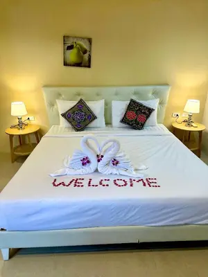 a white bed with two white bows on it at Theclickguesthouse in Ban Bang Chak