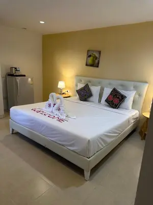a bedroom with a large bed with white sheets and pillows at Theclickguesthouse in Ban Bang Chak