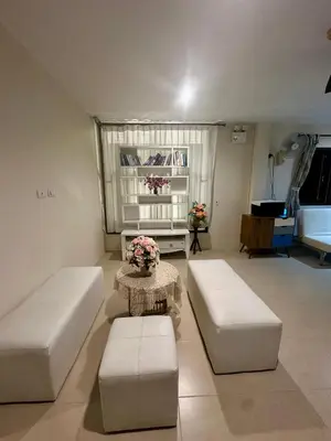 a living room with two white couches and a table at Theclickguesthouse in Ban Bang Chak