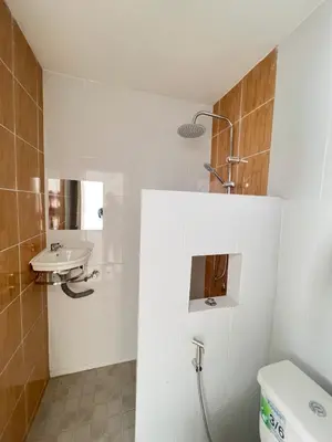 a white bathroom with a sink and a toilet at Tim House Thalang Phuket 1 in Thalang