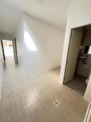 an empty room with a white wall and a wooden floor at Tim House Thalang Phuket 1 in Thalang