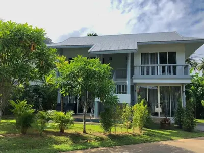 a house with trees in front of it at Casa Sakhu Beach Villa Phuket in Nai Yang Beach