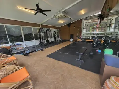 a gym with several tread machines and a ceiling fan at Casa Sakhu Beach Villa Phuket in Nai Yang Beach