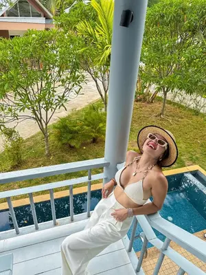 a woman in a bikini sitting on a chair at Casa Sakhu Beach Villa Phuket in Nai Yang Beach