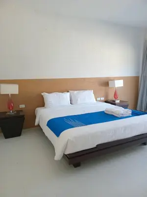 a bedroom with a large bed with blue sheets and white pillows at PaKrongCheep Homestay in Ban Muang Mai