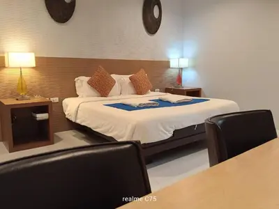 a bedroom with a bed with two tables and two chairs at PaKrongCheep Homestay in Ban Muang Mai