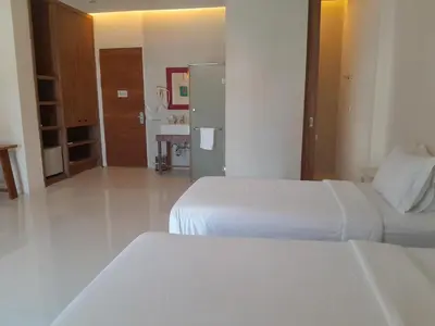 a hotel room with two beds and a bathroom at Pimnara Boutique Hotel By Simply Serene in Patong Beach