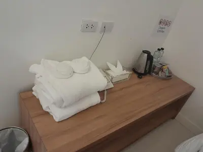 a pile of towels sitting on top of a wooden counter at Pimnara Boutique Hotel By Simply Serene in Patong Beach