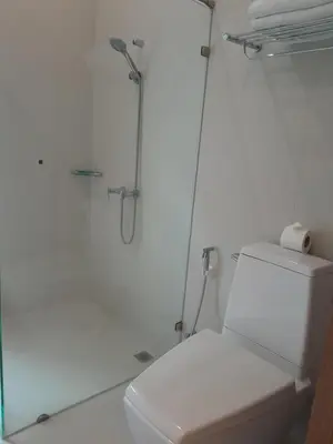 a white bathroom with a shower and a toilet at Pimnara Boutique Hotel By Simply Serene in Patong Beach