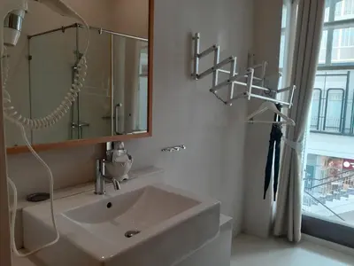 a bathroom with a sink and a mirror and a window at Pimnara Boutique Hotel By Simply Serene in Patong Beach