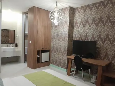 a living room with a desk and a television at Pimnara Boutique Hotel By Simply Serene in Patong Beach