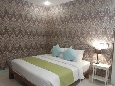 a bedroom with a bed with a patterned wall at Pimnara Boutique Hotel By Simply Serene in Patong Beach
