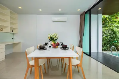 a dining room with a white table and chairs at 4BR Villa B5 with Pool, Vibrant Life at Kata Beach - UTK5 in Kata Beach
