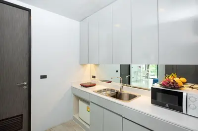 a white kitchen with a sink and a microwave at 4BR Villa B5 with Pool, Vibrant Life at Kata Beach - UTK5 in Kata Beach