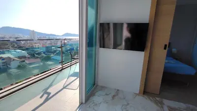 a door to a balcony with a view of a city at Emerald Terrace Resort 2 bedrooms Panoramic Ocean View Top Floor in Patong Beach