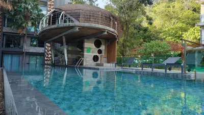 a building with a swimming pool with a tree house at Emerald Terrace Resort 2 bedrooms Panoramic Ocean View Top Floor in Patong Beach