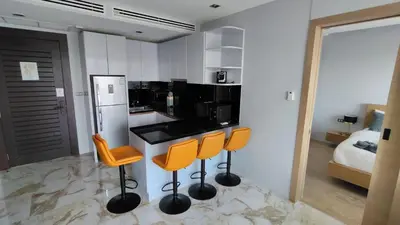 a kitchen with a black counter and orange bar stools at Emerald Terrace Resort 2 bedrooms Panoramic Ocean View Top Floor in Patong Beach