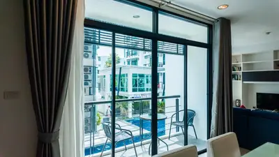 a room with a large window with a view of a pool at Apartment 2 bedrooms on Kamala in Phuket Town