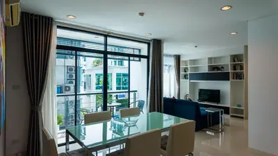 a dining room with a glass table and a large window at Apartment 2 bedrooms on Kamala in Phuket Town