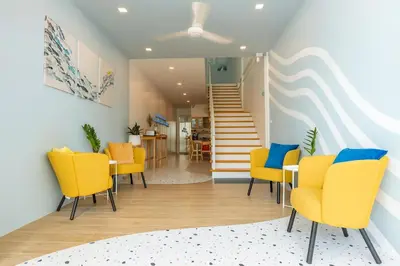 a dining room with yellow chairs and a staircase at Sea Side at Ao Nang Landmark Night Market Krabi in Ban Khlong Haeng