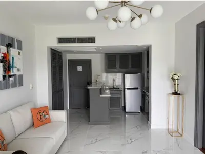 a living room with a couch and a kitchen at Allamanda Laguna in Laguna Phuket
