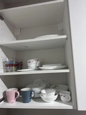 a white shelf with cups and dishes on it at Chic Condo Karon A512 in Karon Beach