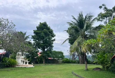 a park with palm trees and a white monument at Chic Condo Karon A512 in Karon Beach