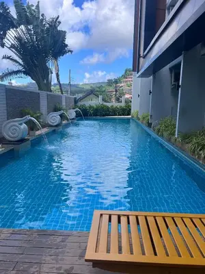 a swimming pool with a bench in front of a building at Chic Condo Karon A512 in Karon Beach