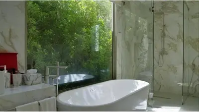 a white bath tub in a bathroom with a window at Beachfront Luxury villa near Banyan Tree in Layan Beach