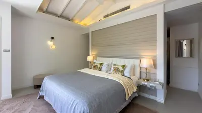 a bedroom with a large bed with a blue comforter at Beachfront Luxury villa near Banyan Tree in Layan Beach
