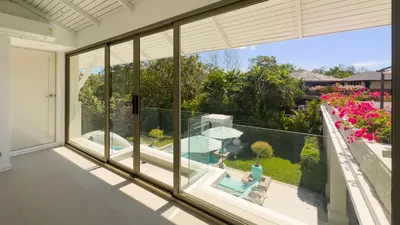 a room with a large window looking out at a pool at Beachfront Luxury villa near Banyan Tree in Layan Beach