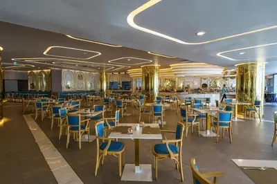 a dining room with tables and blue chairs at Wonderful View Duplex in La Vita in Rawai Beach