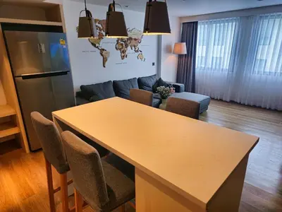 a kitchen and living room with a table and a couch at Wonderful View Duplex in La Vita in Rawai Beach