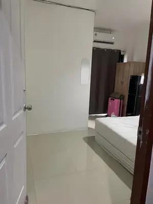 a white bedroom with a bed and a pink suitcase at CİMELi Guest House in Patong Beach