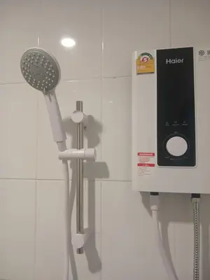 a bathroom with a shower with a hair dryer at CİMELi Guest House in Patong Beach