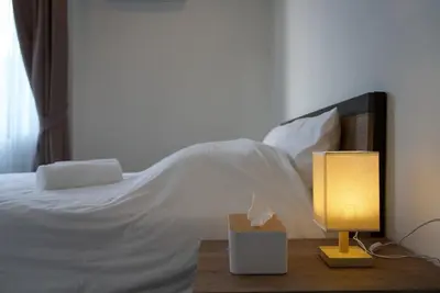 a bedroom with a bed and a table with a lamp at Private pool villa bangtao - laguna park in Ban Phru Champa