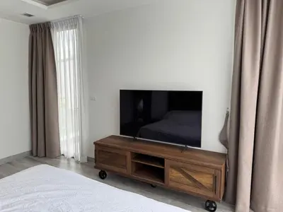 a bedroom with a flat screen tv on the wall at Private pool villa bangtao - laguna park in Ban Phru Champa