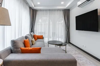 a living room with a couch and a flat screen tv at Med Village by Villacarte in Nai Harn Beach