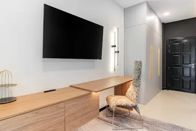 a room with a desk and a television on a wall at Med Village by Villacarte in Nai Harn Beach